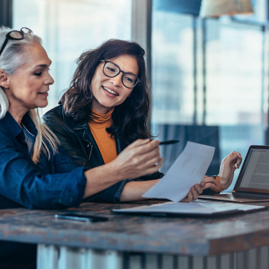 A stock photo of two women looking at a piece of paper