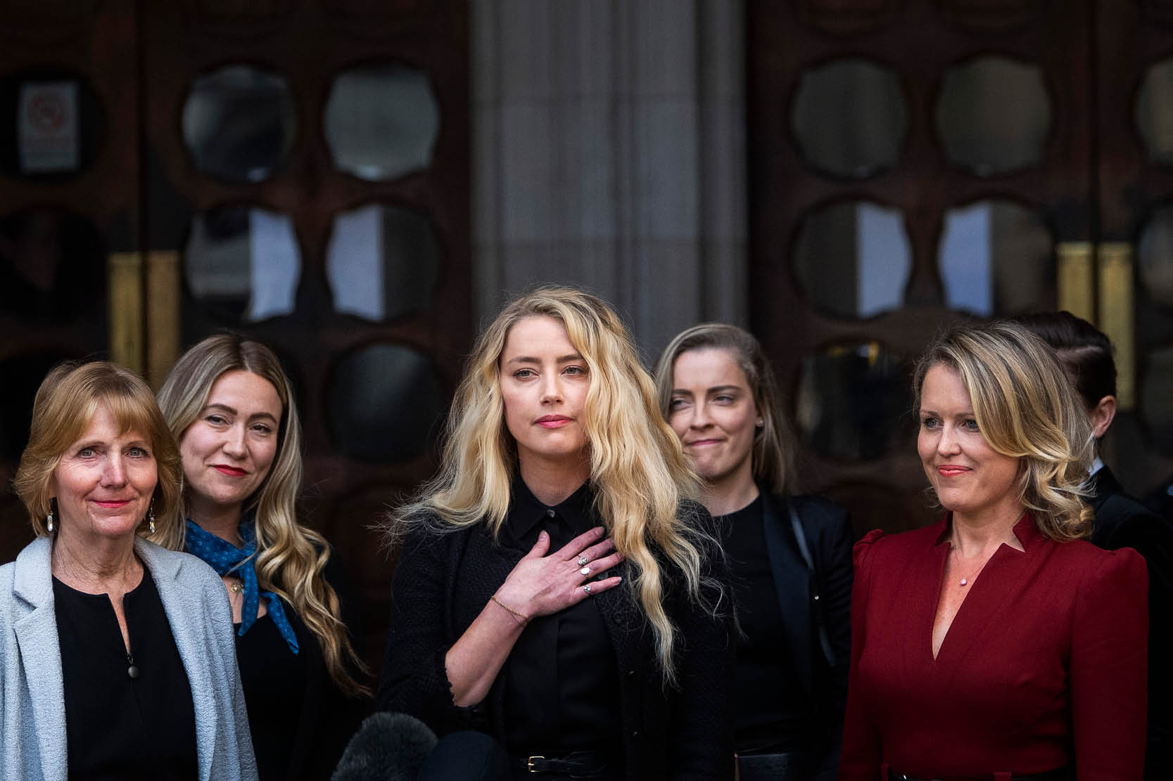 Actress Amber Heard, alongside her sister Whitney Henriquez (second right) and lawyer Jen Robinson (right), as she gives a statement outside the High Court in London on the final day of hearings in Johnny Depp's libel case against the publishers of The Sun